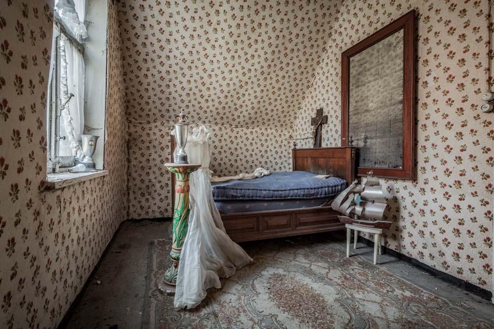 Ferme de Maraichage. Urbex in België. De slaapkamer met de prachtige bruidsjurk.