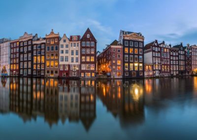 Steden. Damrak Amsterdam. Een panorama in het blauwe uurtje.