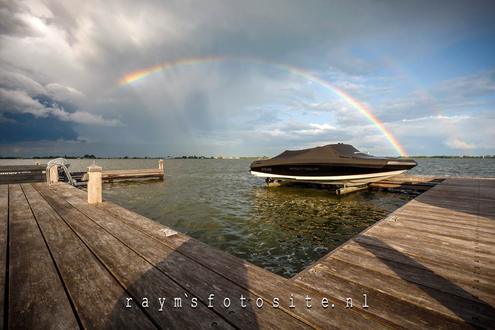 Dubbele regenboog boven het water.