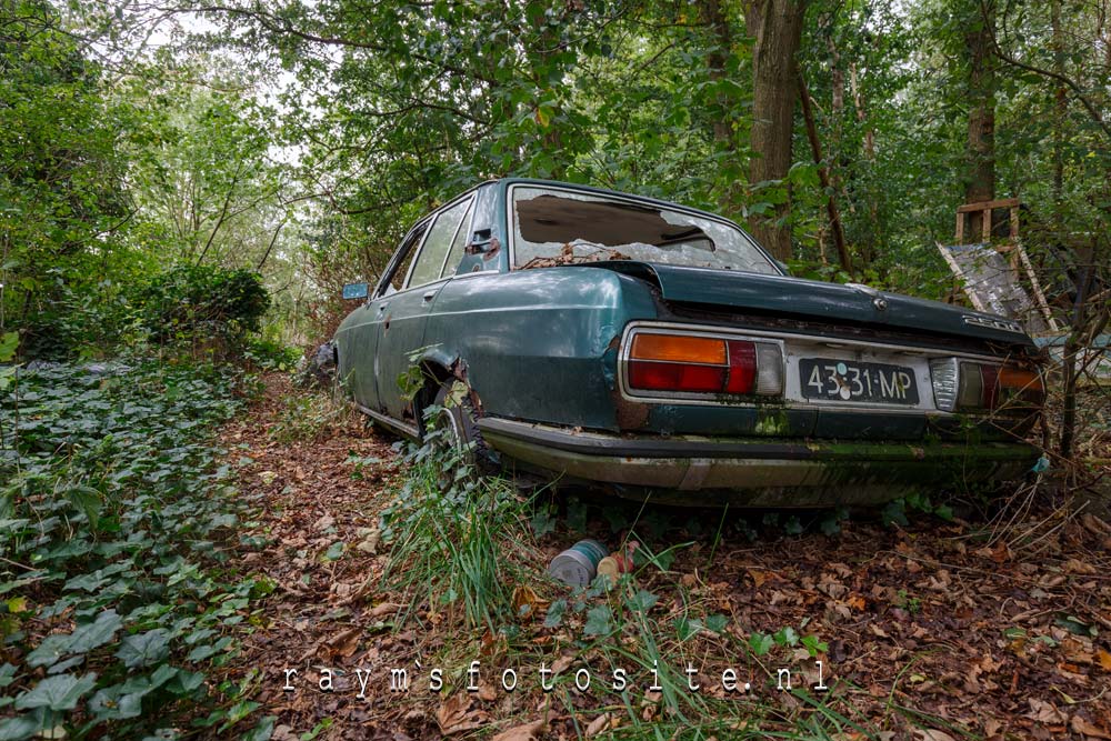 Een oude BMW in het bos in Nederland.