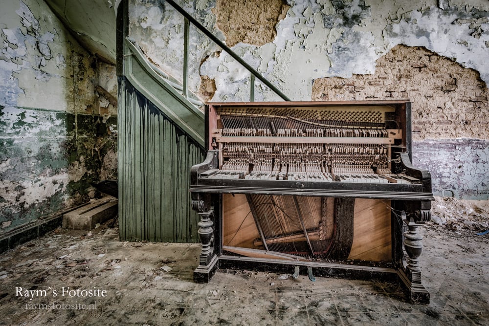 De mooie oude piano met erachter de lekkere vervallen muren.