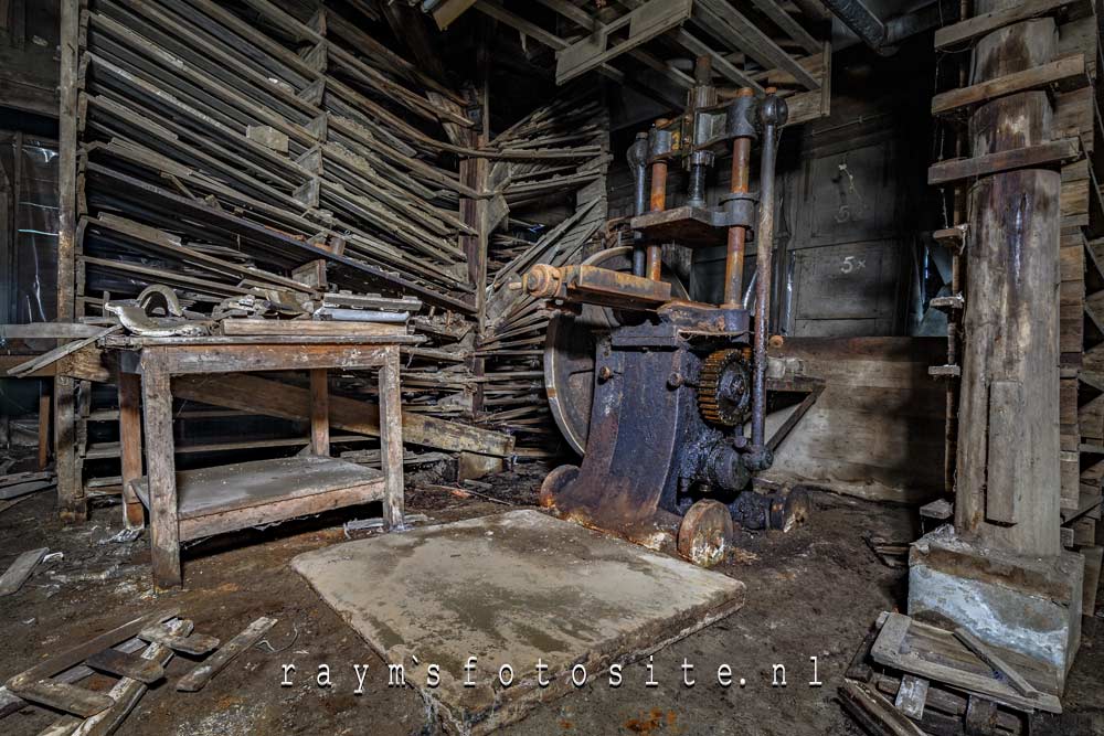 In een donkere ruimte staan diverse oude machines in deze verlaten fabriek.