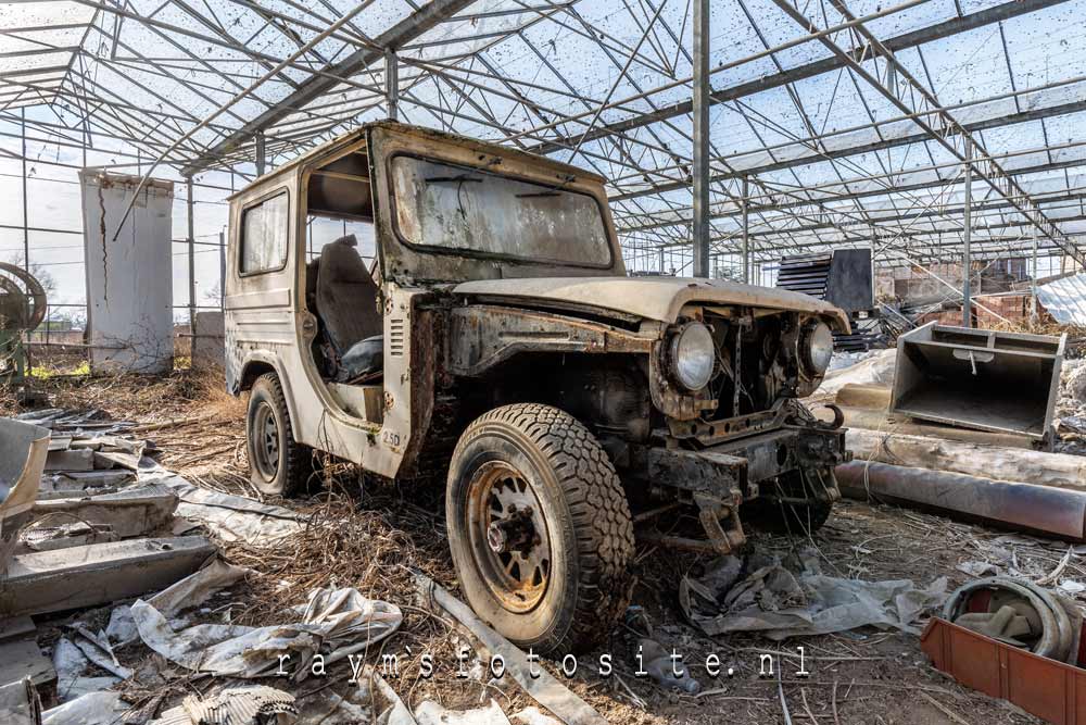 Mooie oude Jeep, achtergebleven in een rommelige kas.