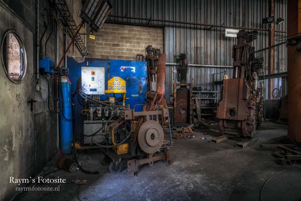 Heavy Metal. Verlaten staalindustrie in België. Je kijkt hier naar een werkplaatsje waar een kantelmachine voor staalrollen staat.