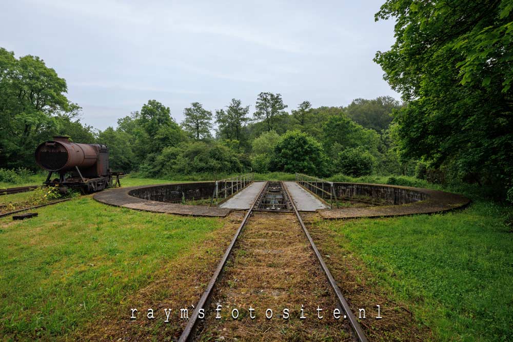 Een urbexlocatie met treinen, locomotieven en oude wagons.