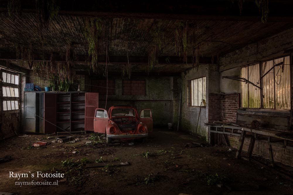 Napoleon Bug, urbexlocatie. Een oude rode Volkswagen kever in een verlaten garage.