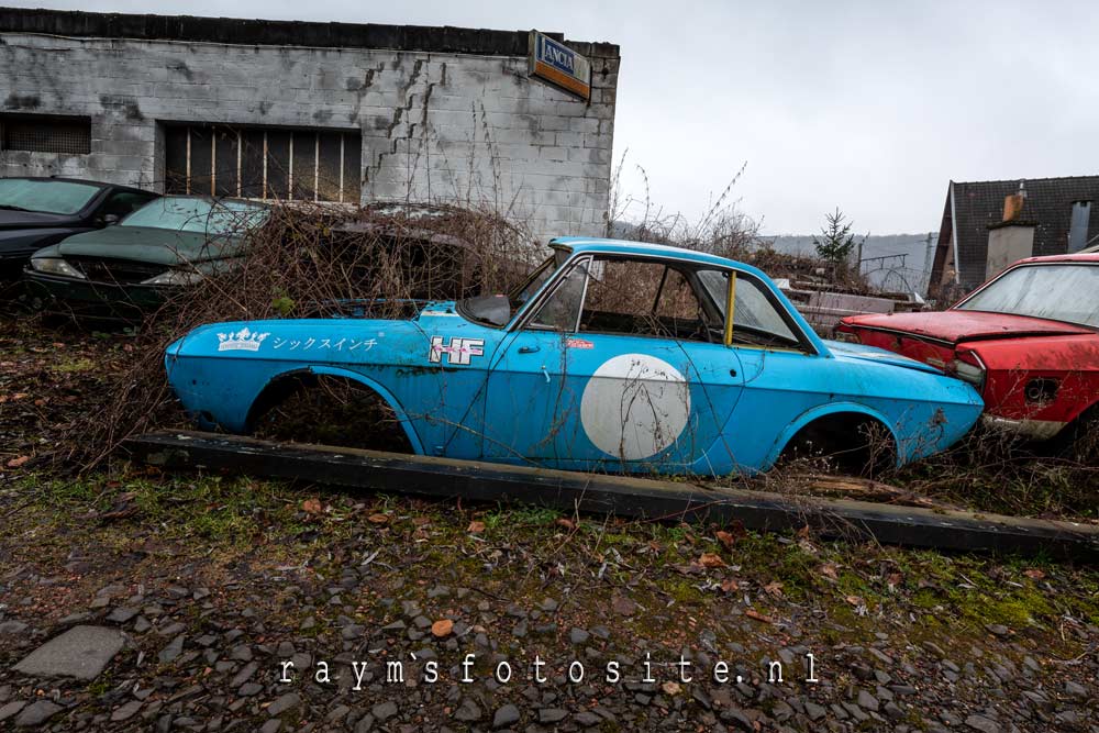 Verlaten sportauto`s in België bij een oude garage.