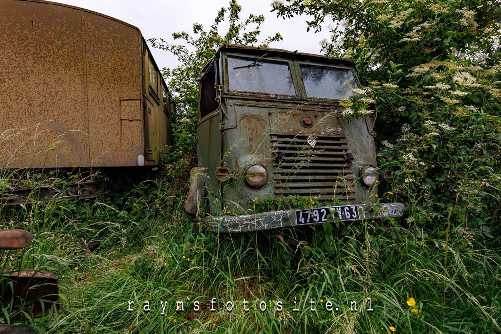 Rusty Giants. Auto`s in een veld langzaam door de natuur overgenomen.