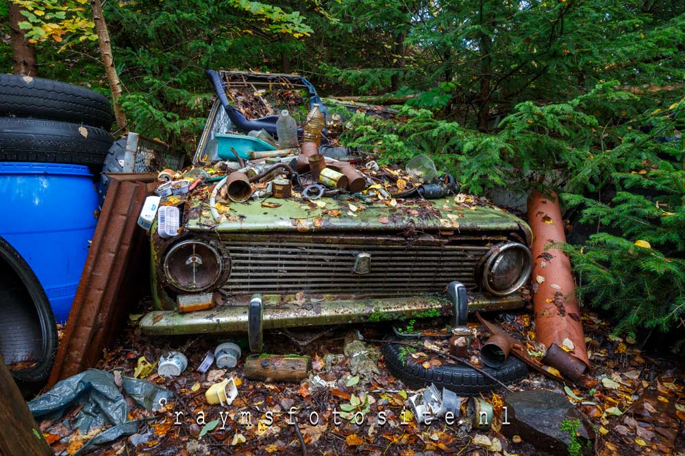 Een oude zwaar vervallen verlaten Peugeot in het bos