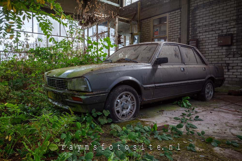 Daarnaast stond er een oude Peugeot in de verlaten garage.